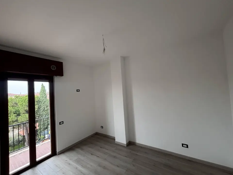 Ambiente ristrutturato con pavimento in legno e porta-finestra